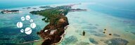 Das Foto zeigt karibisch-blaues Meer mit einer grünen Insel. - vergrösserte Ansicht