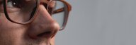 Close-up of a man wearing glasses. - enlarged view