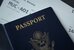 Ein dunkelblaues Büchlein, auf dem in goldenen Buchstaben "Passport" steht. Darin steckt ein Flugticket. - vergrösserte Ansicht