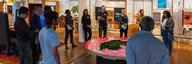 In der Ausstellung des Museums für Kommunikation stehen zahlreiche Menschen mit unterschiedlichen Hintergründen um einen runden Tisch, auf dem die Schweiz abgebildet ist. - vergrösserte Ansicht