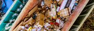 Aufnahme von drei grossen Abfallmulden von oben. Darin stapeln sich Papier, Metall und Grüngut getrennt. - vergrösserte Ansicht