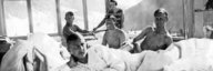 Junge Männer, teilweise mit nacktem Oberkörper, liegen in ihren Sanatoriumsbetten an der Sonne. - vergrösserte Ansicht