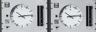 Schwarz-weiss Foto von mechanischen Apparaturen mit zahlreichen Knöpfen und zwei grossen Uhren darauf. - vergrösserte Ansicht