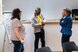 Drei Personen unterschiedlicher Herkunft stehen beisammen vor einem Flipchart und sind im Gespräch.