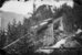 Historische schwarz-weiss Aufnahme: Über einen Wildbach im Wald führt die Brücke einer Bergbahn. Im Hintergrund ist das Grandhotel Giessbach zu sehen. - vergrösserte Ansicht