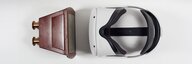 Eine Virtual-Reality-Brille liegt auf weissem Grund - ihr gegenüber ein historisches Stereoskop aus Holz. - vergrösserte Ansicht