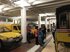 Besuch im Museumsdepot: zwischen gelben Kutschen und Autos stehen die Kinder - vor ihnen erzählt ein Museumsmitarbeiter.