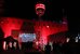 Das Museum für Kommunikation bei Nacht, getaucht in rotes Licht, im Vordergrund zahlreiche Museumsnachtbesuchende. - vergrösserte Ansicht
