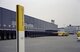 Blick auf das Graue Paketzentrum in Härkingen. Im Vordergrund steht ein gelbes Schild auf dem "Die Post" steht.