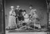 Eine historische Aufnahme von sechs Frauen und Männern, die in einem Fotostudio mit Kulisse und Verkleidung als Berggänger:innen posieren. - vergrösserte Ansicht