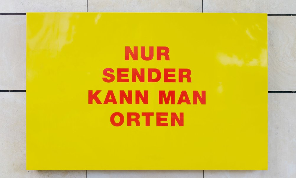 Ein Foto eines gelben Schildes, auf dem in roter Schrift steht: Nur Sender kann man orten.