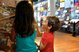 A girl and a boy steer a post bus through a labyrinth with a magnet. The background is blurred.