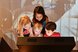 In front of a video projection, four children bend over a screen. We do not see what is on the screen, but the children look amused and interested.