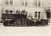 La photographie en noir et blanc montre une vue latérale d'un camion à pont de chargement ouvert, équipé d'une chenille sur l'essieu arrière. Une charrue massive en forme de coin est montée à l'avant. Sur les côtés, le véhicule est équipé d'autres chasse-neige destinés à repousser la neige hors de la zone de circulation.