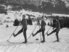 Drei Skifahrer mit Telemarkskis - alle haben einen Ski aufgestellt und posieren für das Foto.