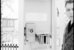 Historisches Foto von 1967: Ein Mann tritt aus einer Telefonkabine, der Blick fällt auf die Inneneinrichtung mit Telefonstation und Telefonbüchern. - vergrösserte Ansicht