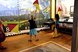 Two girls practise communicating with signal flags. A mountain landscape can be seen behind them.