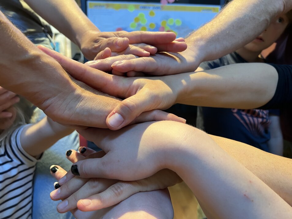 Viele Hände stapeln sich zu einem Händestapel. Dieser Stapel ist von der Seite zu sehen. - vergrösserte Ansicht